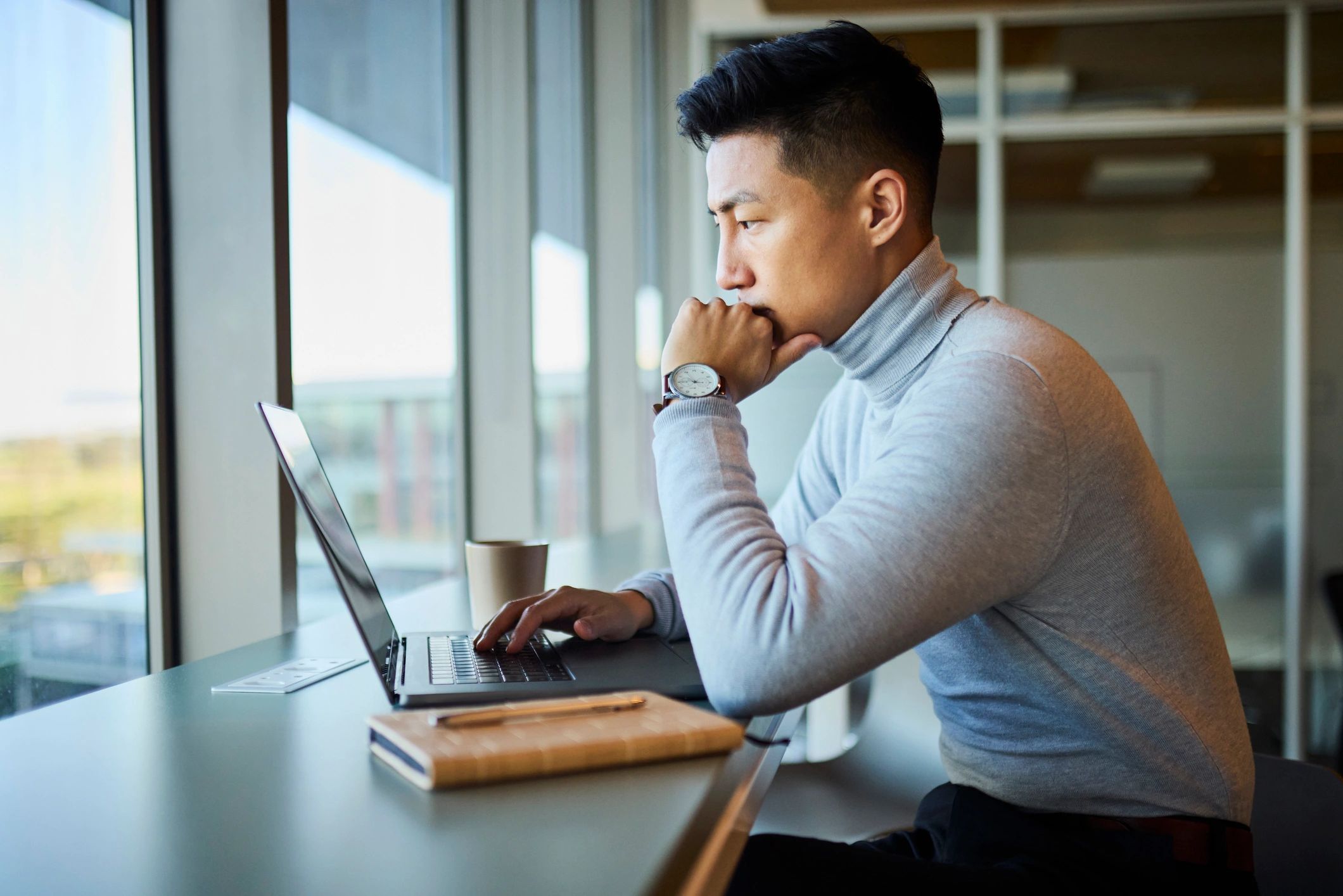 Professional considering next career move while working on a laptop